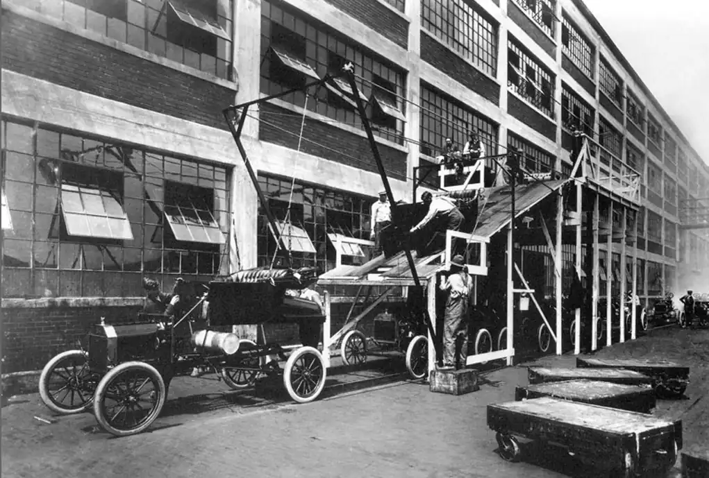 Historic photo of an early automobile assembly line.