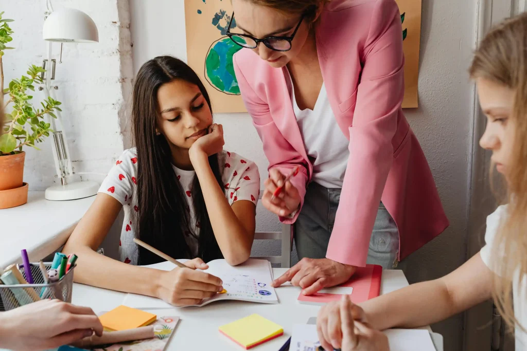 An adult helping students work through a classroom activity.