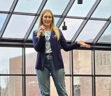 A woman standing on a stage and pitching her business idea